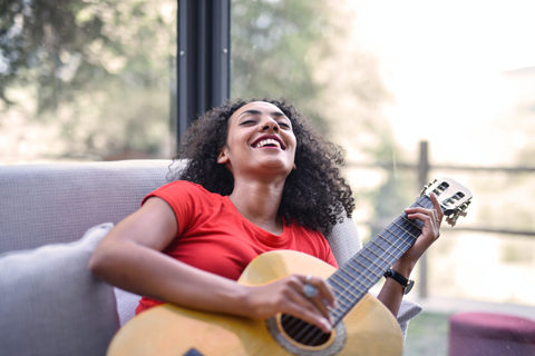 Ragazza sorridente che suona chitarra