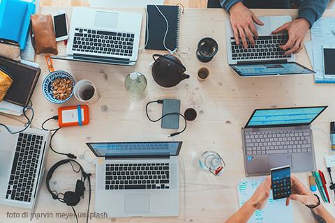Immagine di persone al lavoro con computer e telefoni cellulari