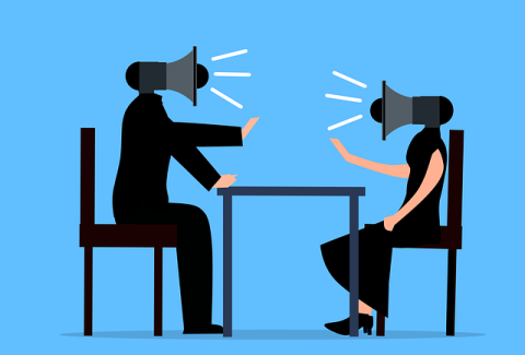 Two people arguing across the table, their heads are megaphones