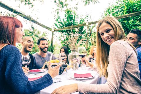 gruppo di giovani ragazzi sorridenti a tavola in un giardino