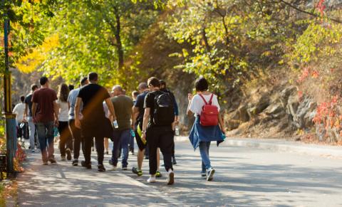 Gruppo di persone cammina per strada in una giornata autunnale