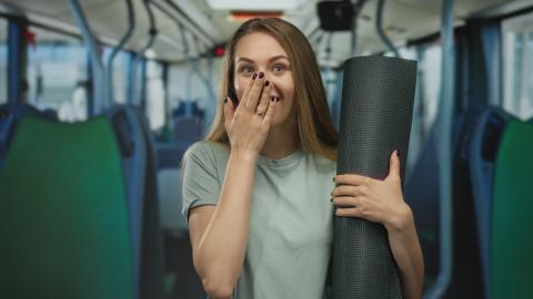 ragazza con tappetino da yoga su un bus